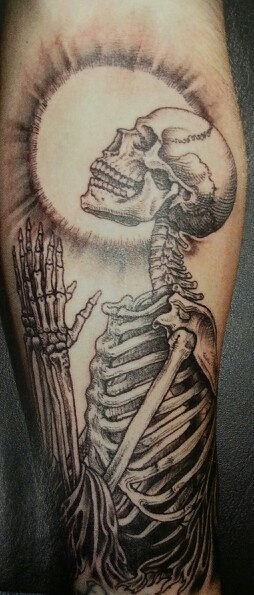 a man's leg with a skeleton tattoo on it