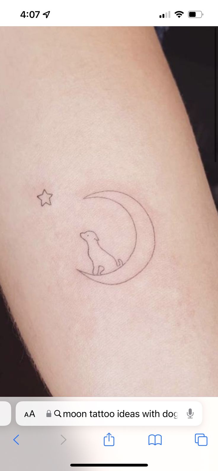 a small tattoo on the arm of a woman with a dog sitting on top of it