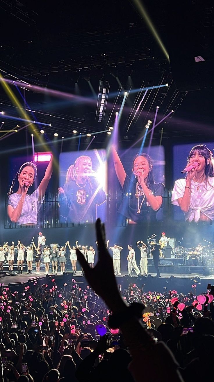 a group of people standing on top of a stage with their hands in the air