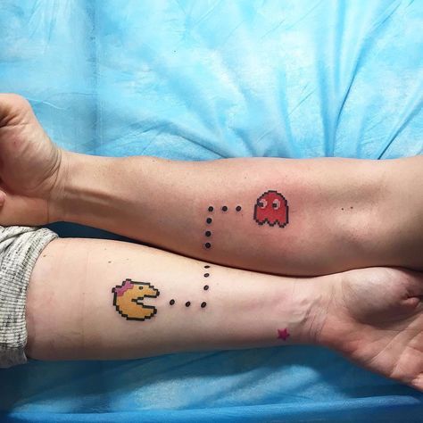 two people with matching tattoos on their legs, one has a pacman and the other has a dog