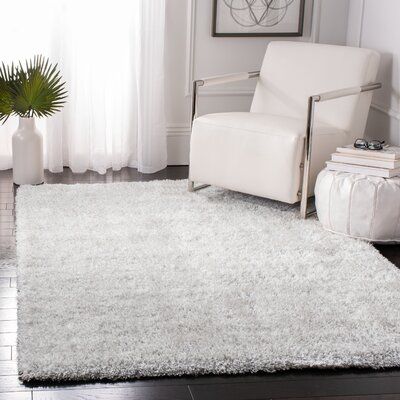 a living room with a white chair and rug