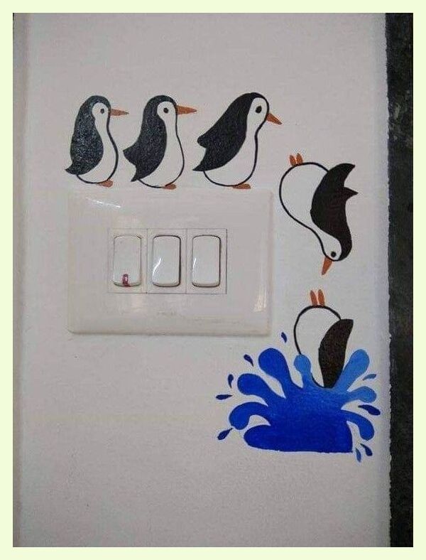 a white light switch with penguins painted on it