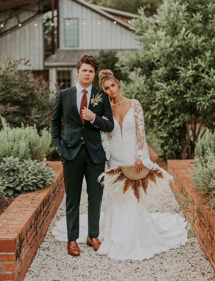 a bride and groom standing in front of a house