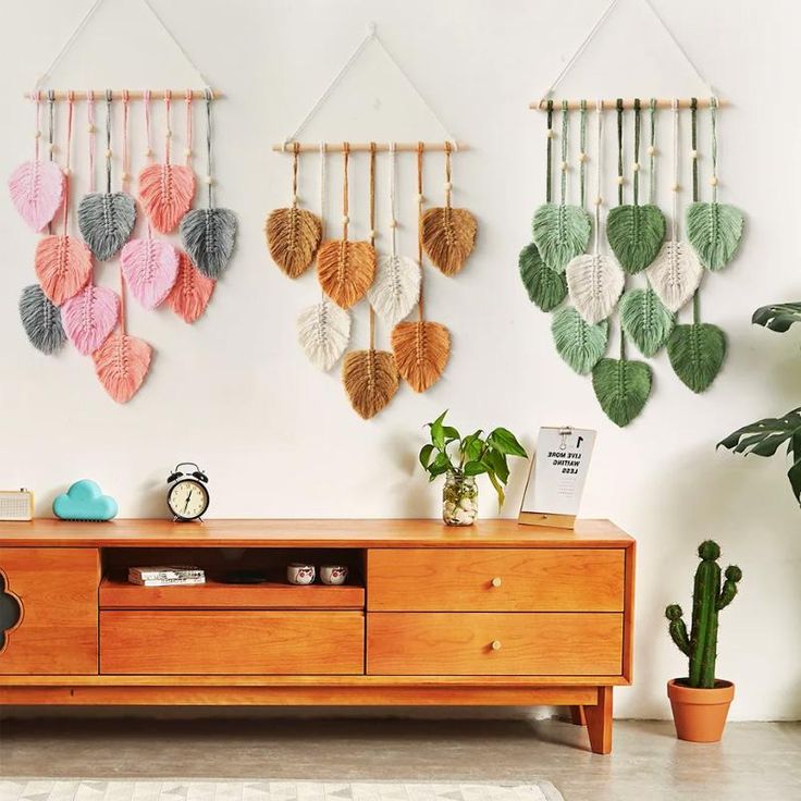 a living room with a wooden dresser and wall hangings on the wall above it