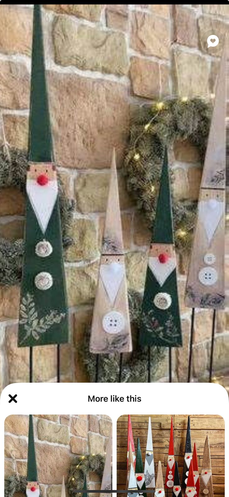 a group of christmas trees sitting on top of a wooden table next to a brick wall