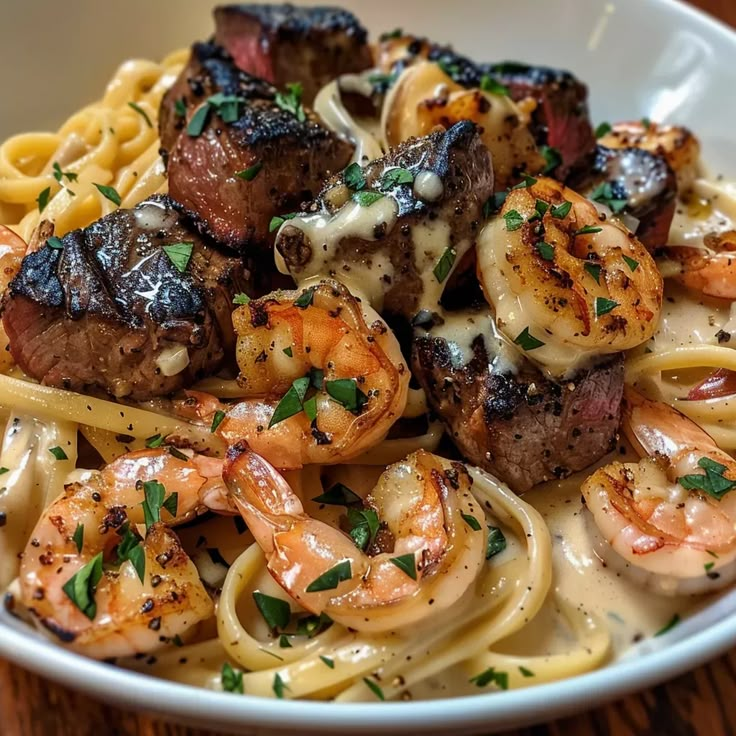 a bowl filled with pasta and shrimp on top of a wooden table