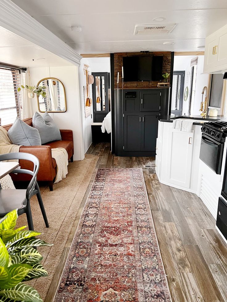 a living room and kitchen area with a rug on the floor