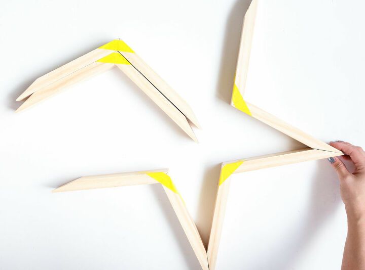 someone is making an origami star out of popsicle sticks