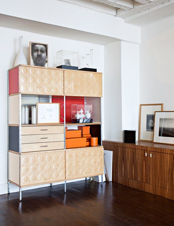 a living room with a book shelf and pictures on the wall next to a wooden floor