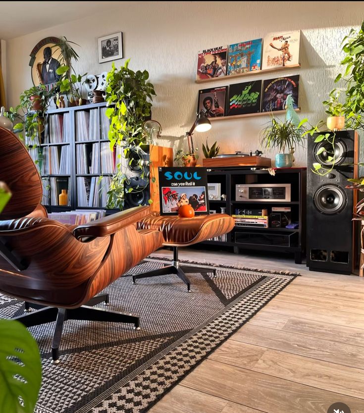 a living room filled with lots of plants next to a tv set and speakers on top of a wooden table