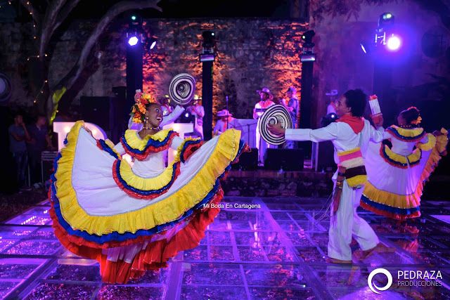 two people in colorful costumes dancing on stage