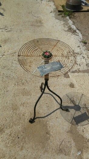 an old metal table with a fan on it