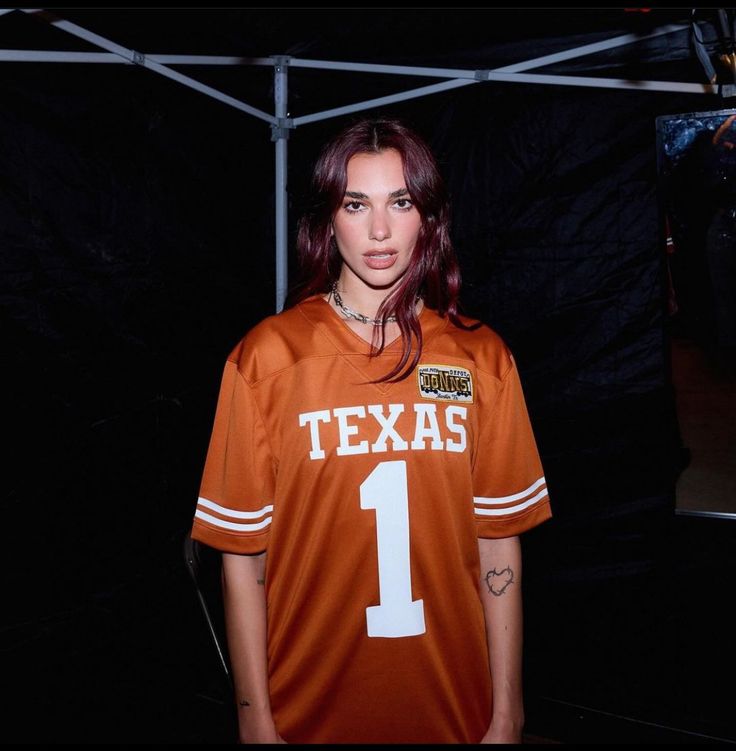 a woman in an orange jersey posing for a photo