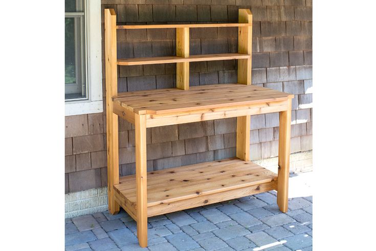 a wooden shelf sitting on top of a brick patio