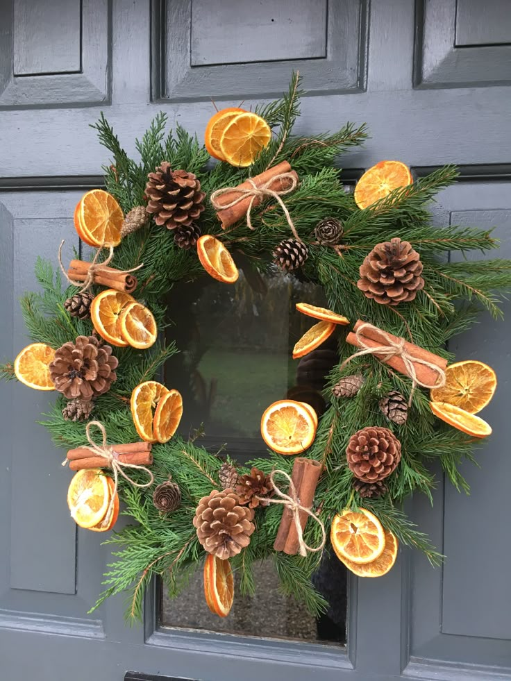 a wreath made out of orange slices and pine cones