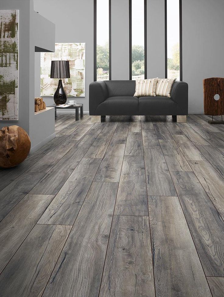 a living room with wood floors and gray furniture