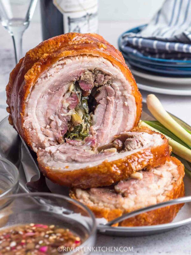 a meatloaf roll is cut in half and served on a plate with asparagus