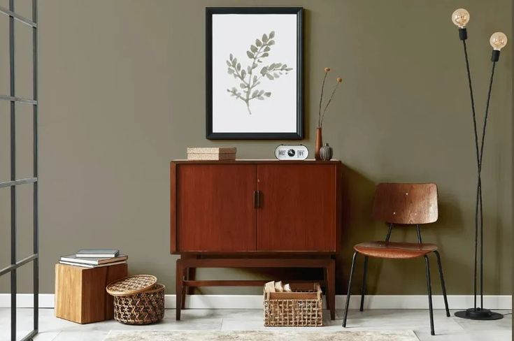 a living room with furniture and decor on the floor, including a chair, sideboard, lamp, rug and pictures