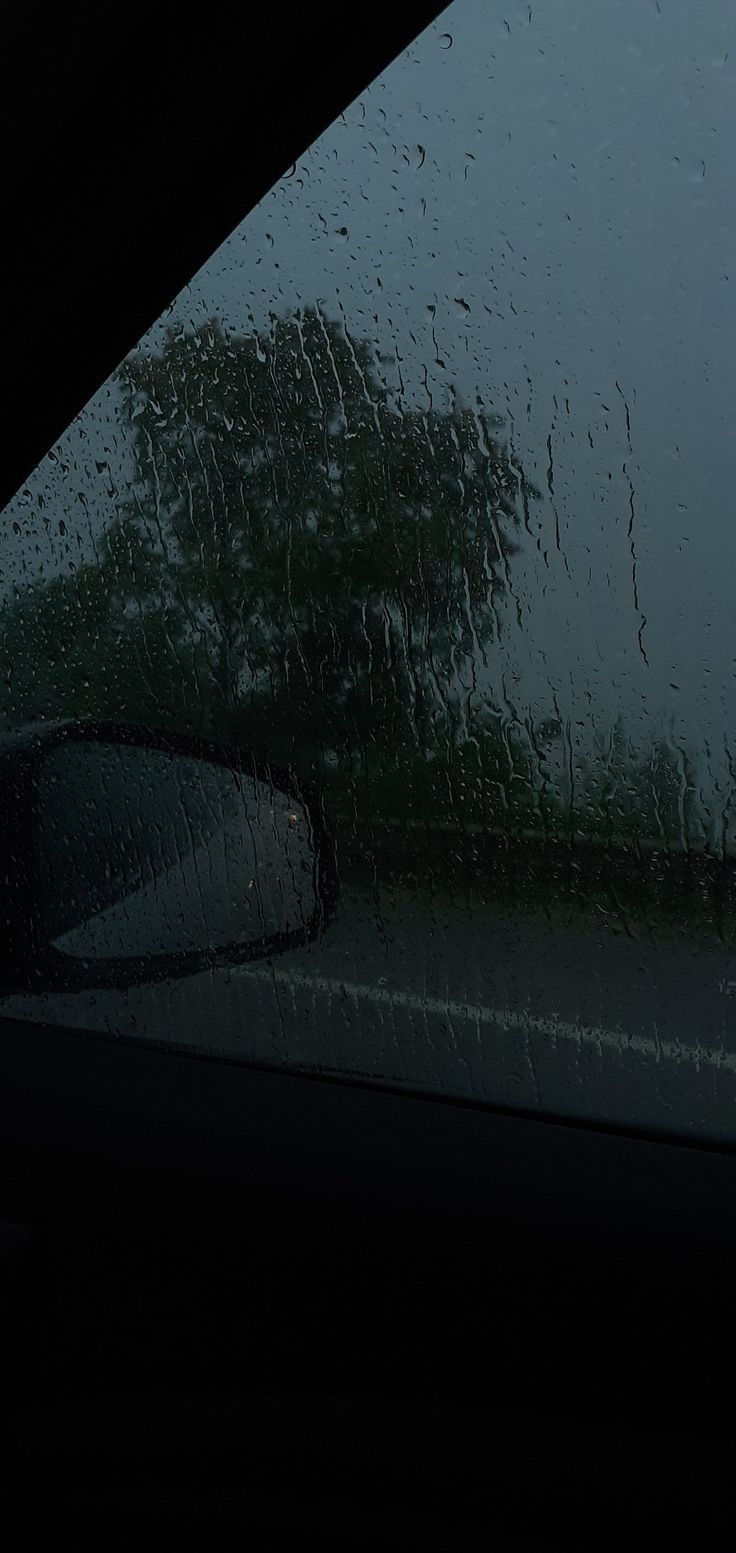 rain is falling on the windshield of a car