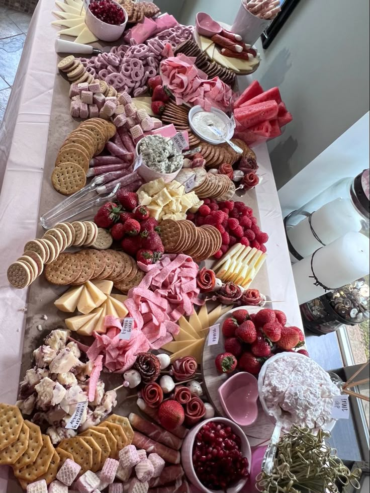 a long table covered with lots of different types of food and desserts on top of it