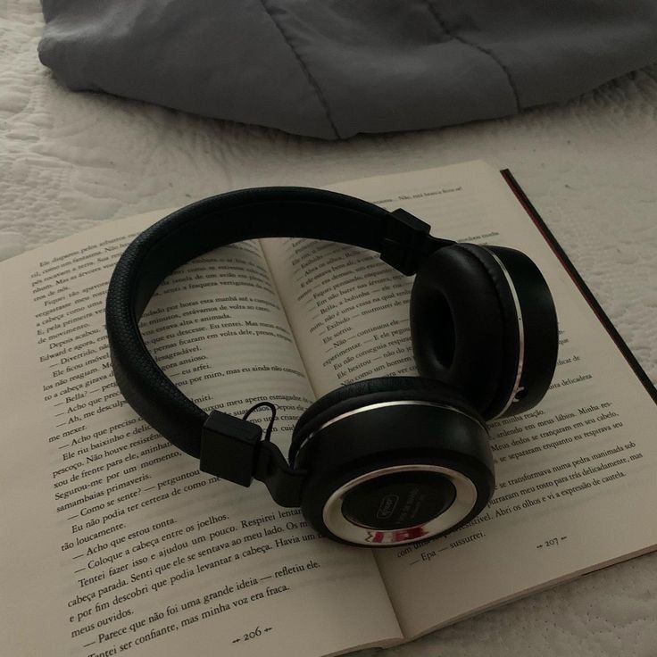 an open book with headphones on top of it