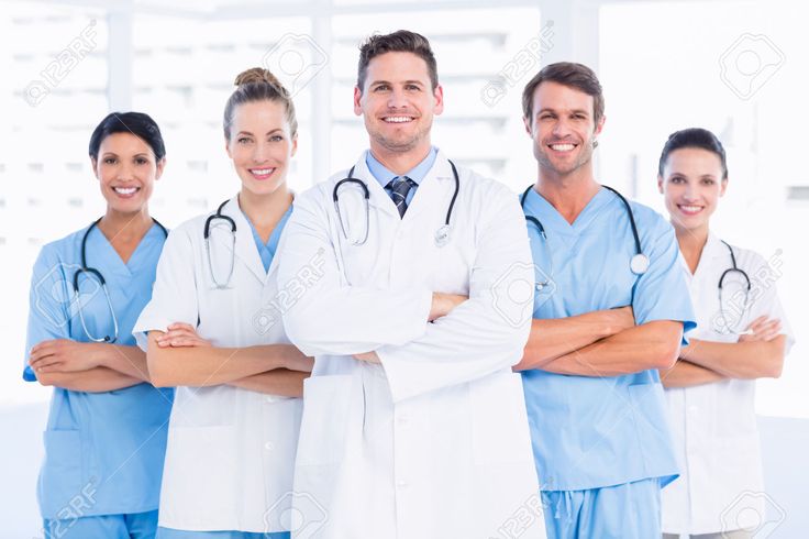 a group of doctors standing together in front of a window with their arms crossed and looking at the camera