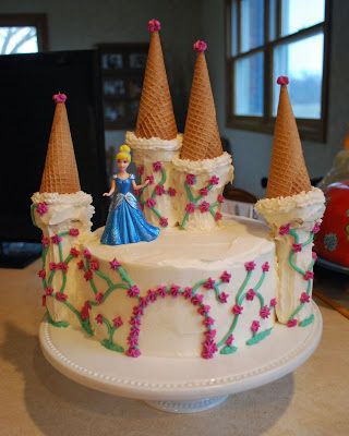 a white cake with frosting and decorations on it sitting on top of a table