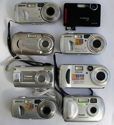 many different types of digital cameras sitting on top of a white table next to each other