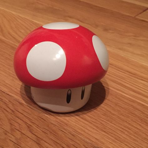 a red and white mushroom sitting on top of a wooden table