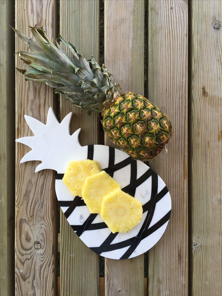 a pineapple and two slices of pineapple sitting on a plate next to each other