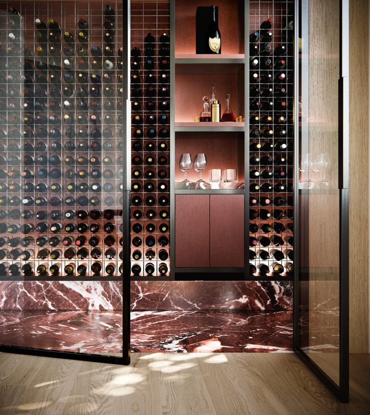 a wine rack in the corner of a room with glass doors and shelves filled with bottles