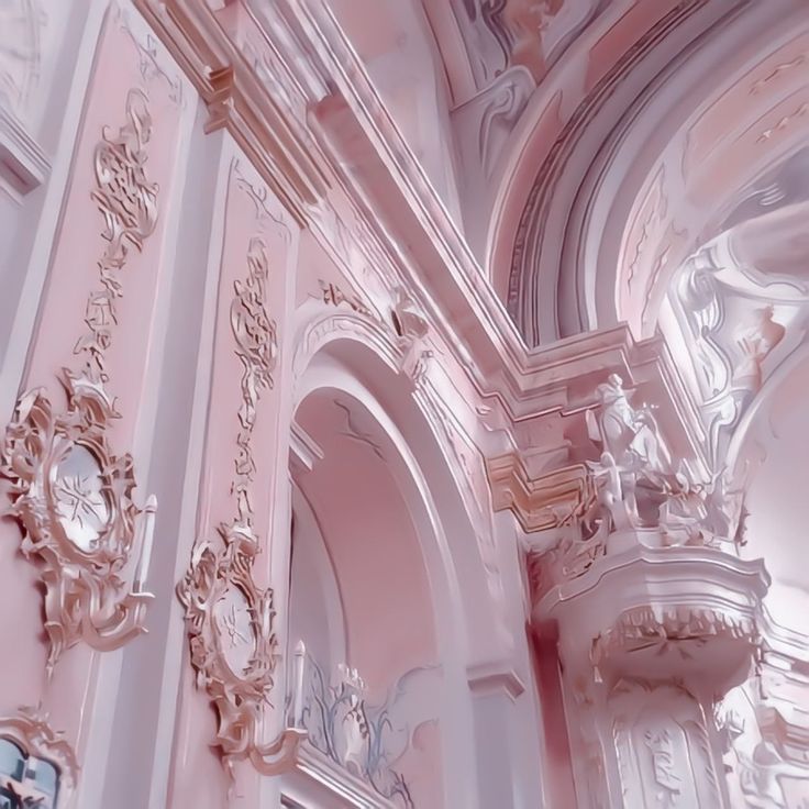 an ornate pink and white building with clocks on the walls