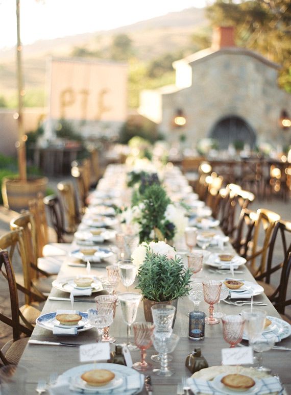 a long table is set up with plates and place settings