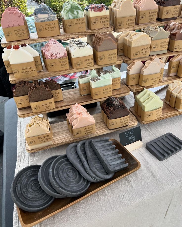 a table topped with lots of different types of cakes and pies on top of wooden trays