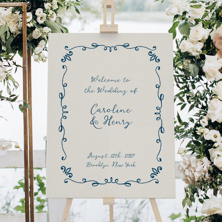 an easel with a sign and flowers on it