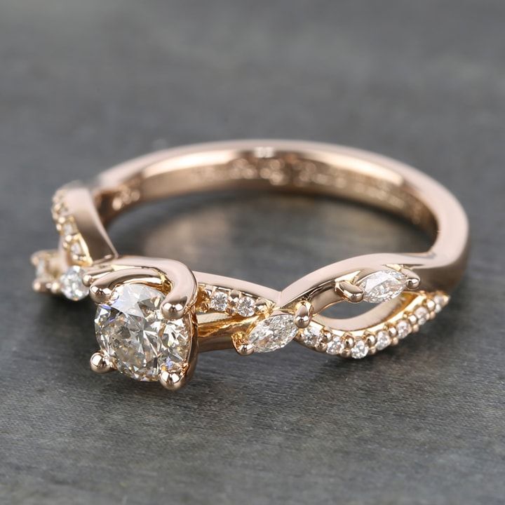 an engagement ring with two diamonds on top and one diamond in the middle, sitting on a gray surface