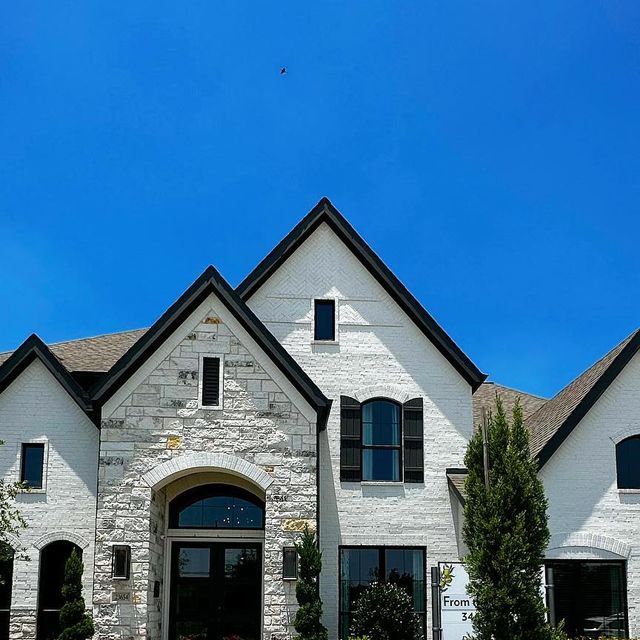 a large white brick house with black windows