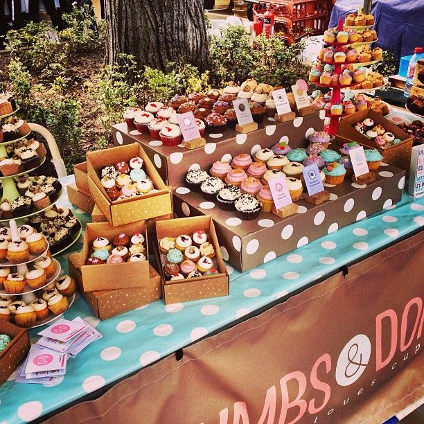 a table topped with lots of cupcakes and pastries on top of it