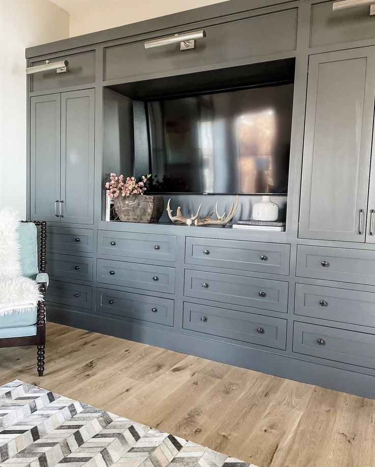 a living room with gray cabinets and a large tv mounted on the back of it