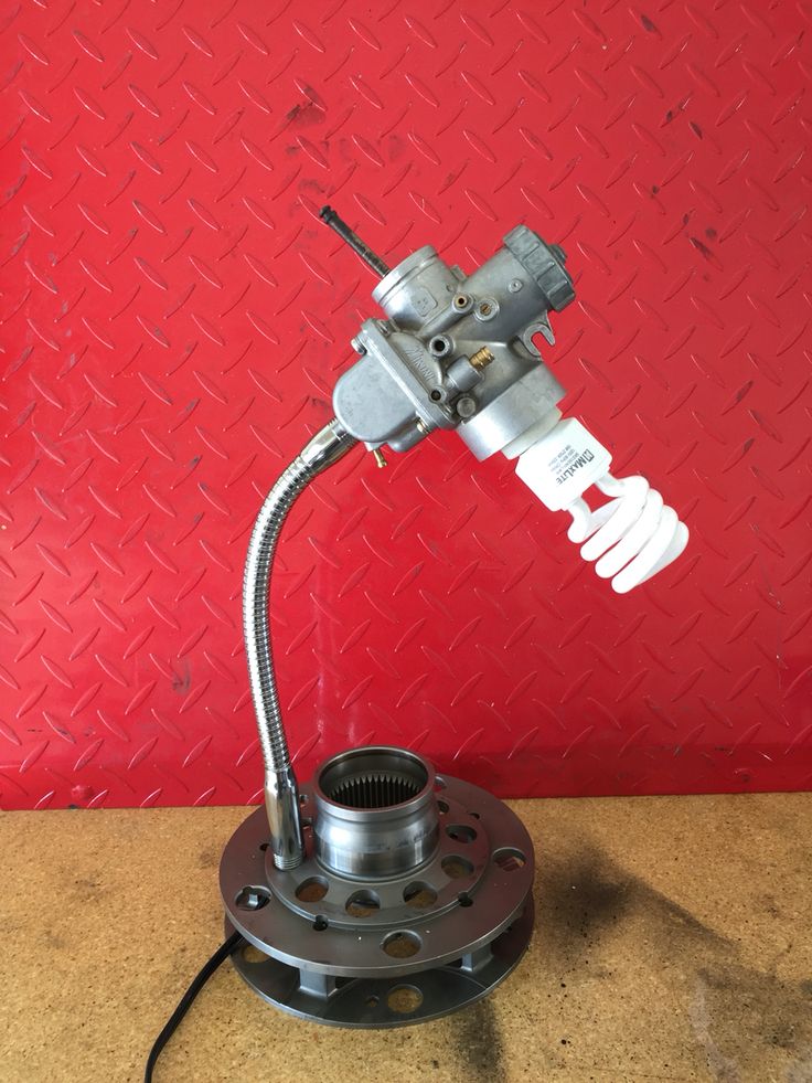 a metal object on top of a table next to a red wall