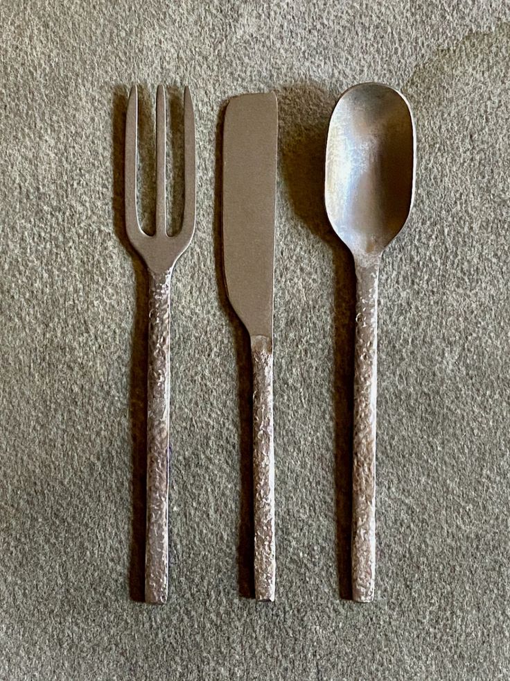 three forks, two spoons and one knife on the floor with carpeted surface