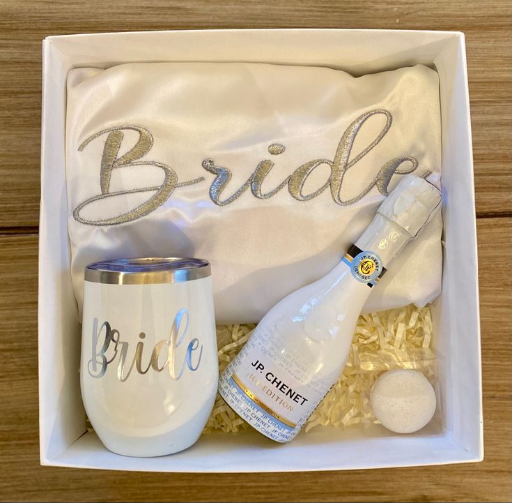 the bride gift box includes a wine glass, a bottle of champagne and a white bag