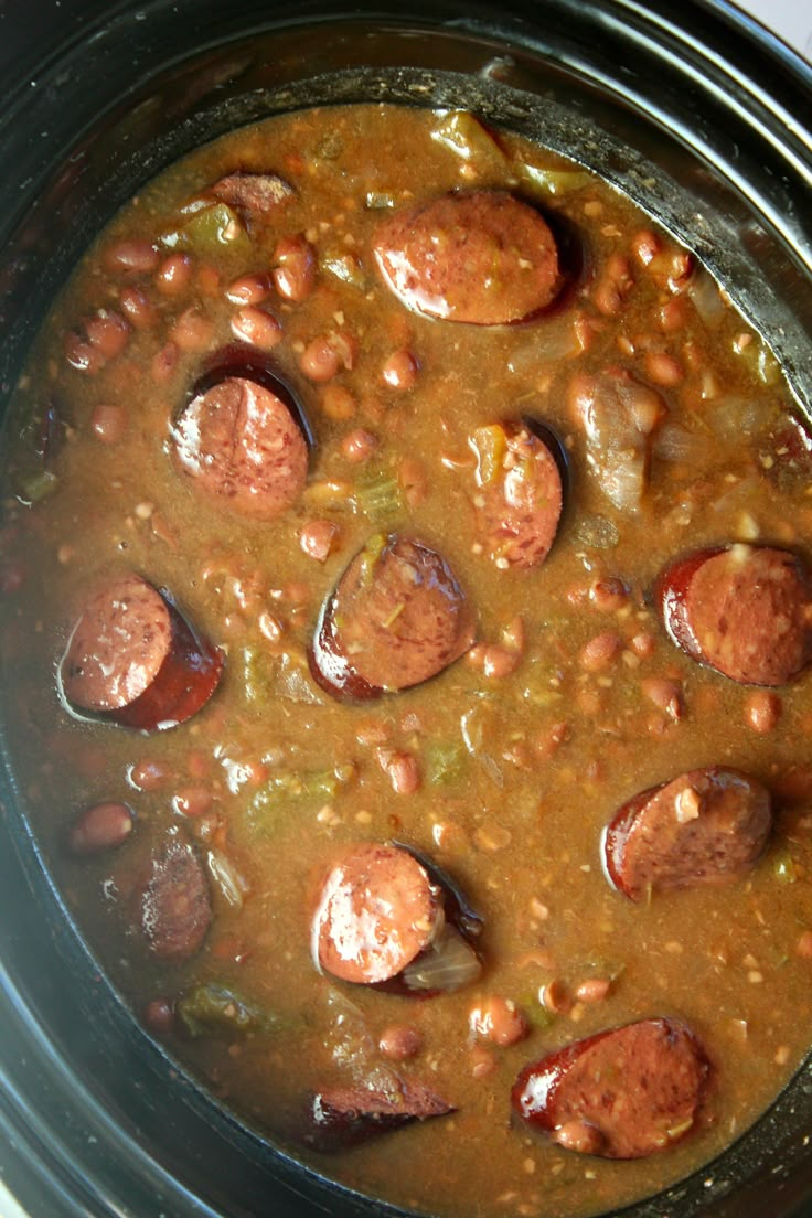 a crock pot filled with beans and sausage