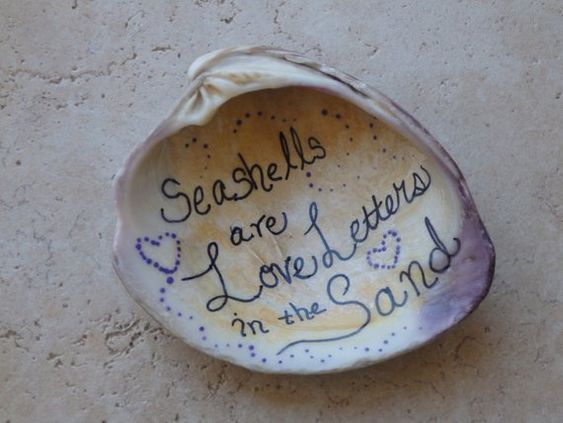 seashells are love letters in the sand with handwritten words on them,