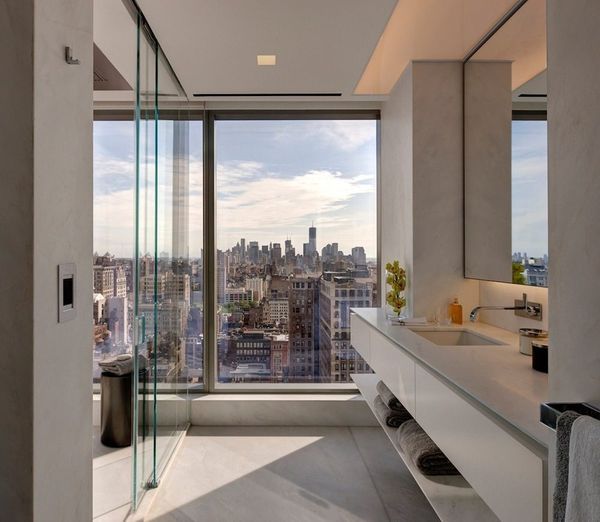 a bathroom with a large window overlooking the city