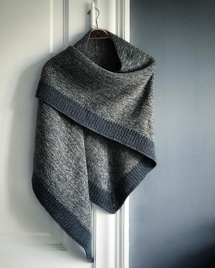 a gray scarf hanging on a white door