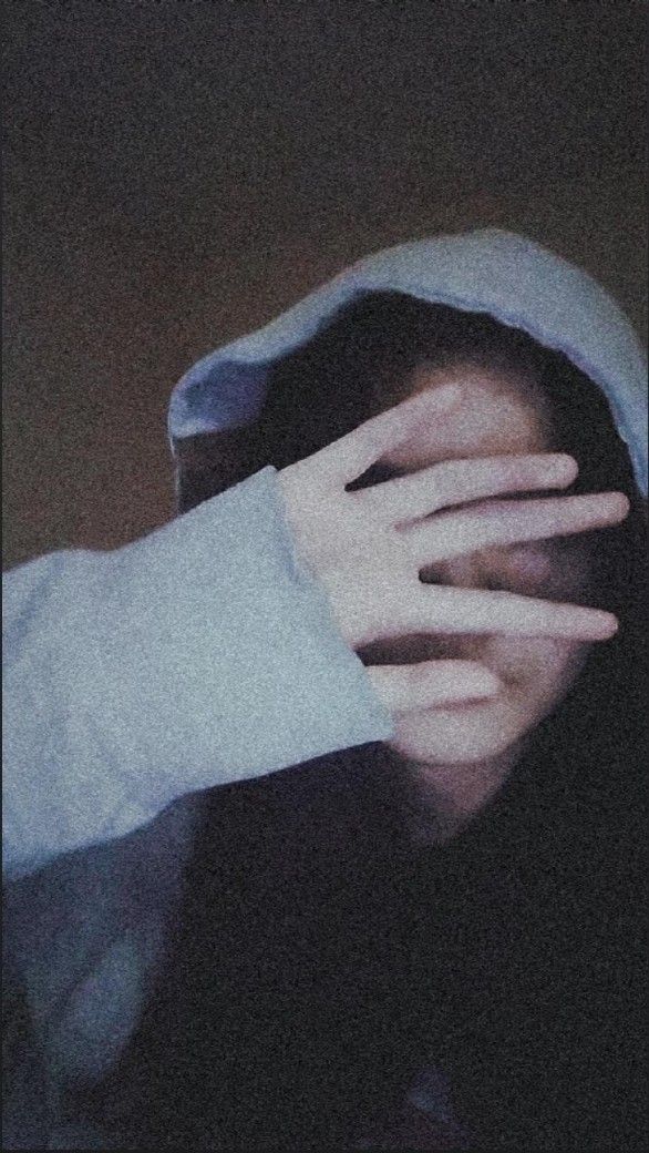 a person covering their face with both hands