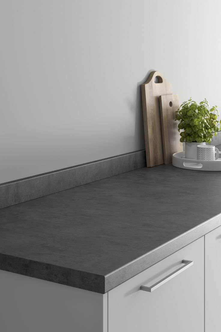 a kitchen counter top with a cutting board and potted plant on it's side