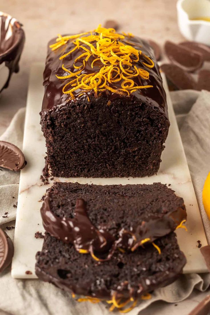 there is a chocolate cake with orange icing on the top and one slice cut off