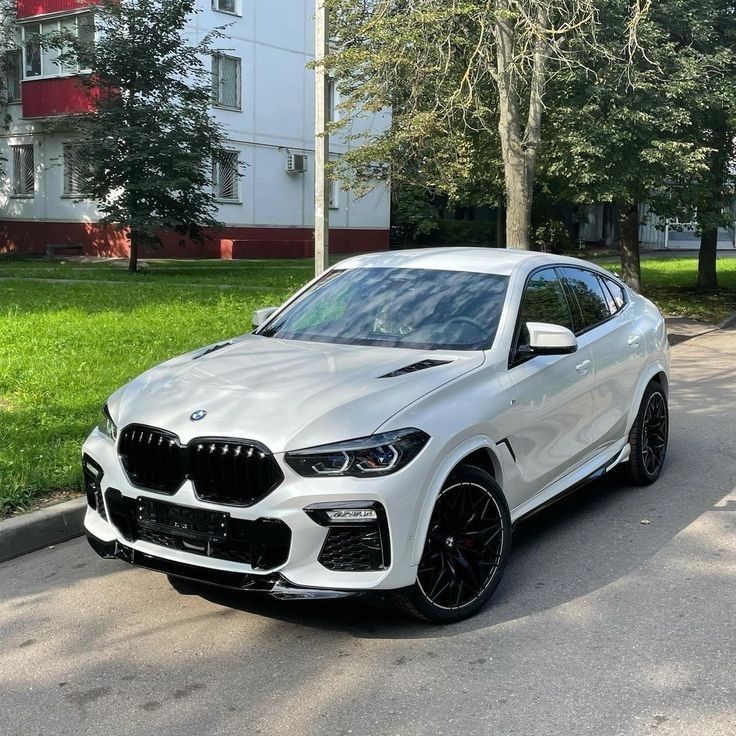 a white bmw suv parked on the street